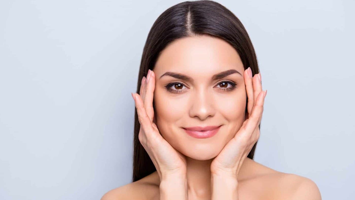 A dermatologist assessing a patient’s facial structure before dermal filler treatment